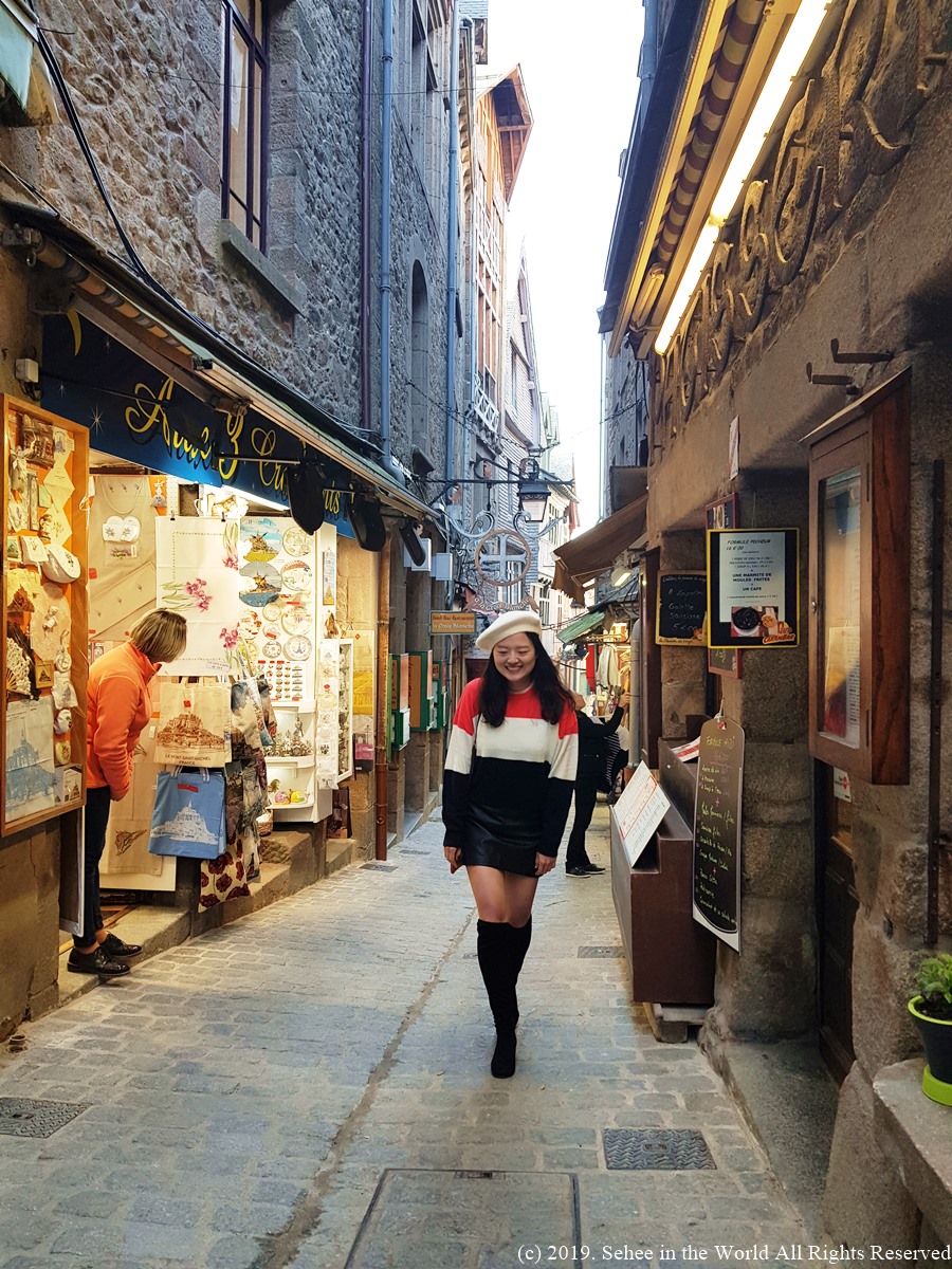 Photo of me taken in the morning at the quiet alley in Mont Saint Michel - Sehee in the World blog