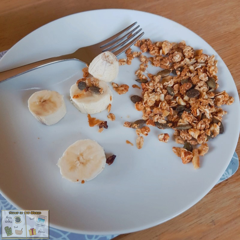 Granola bits and banana slices on a plate as my breakfast, which I originally intended to have with yogurt - photo taken by me, Sehee in the World