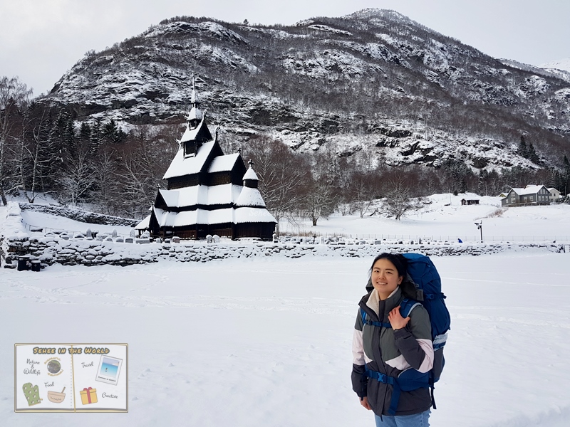 Touristy photo of myself with snowy Borgund Stave Church and the mountain as the background - Sehee in the World